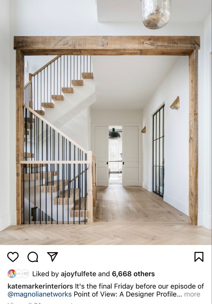 an empty room with wooden floors and stairs leading to the second floor, along with a chandelier