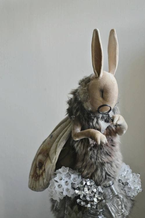 a stuffed animal is sitting on top of a glass jar