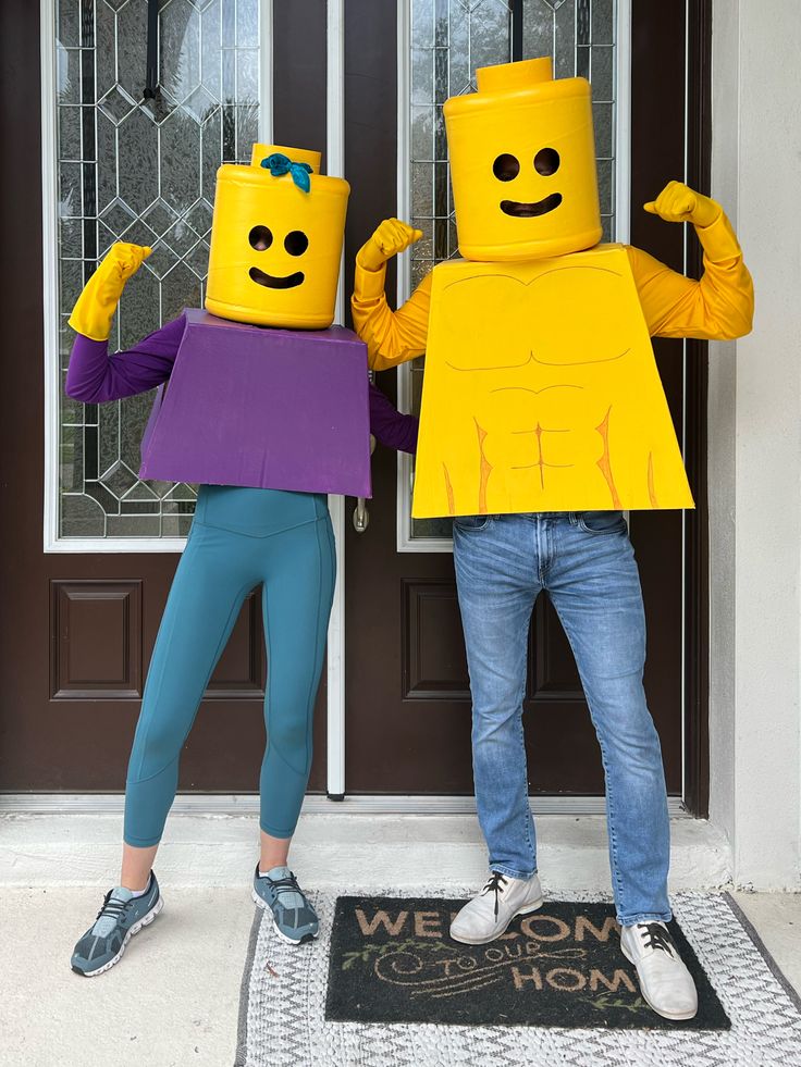 two people dressed up as legos standing in front of a door with their hands on their hips