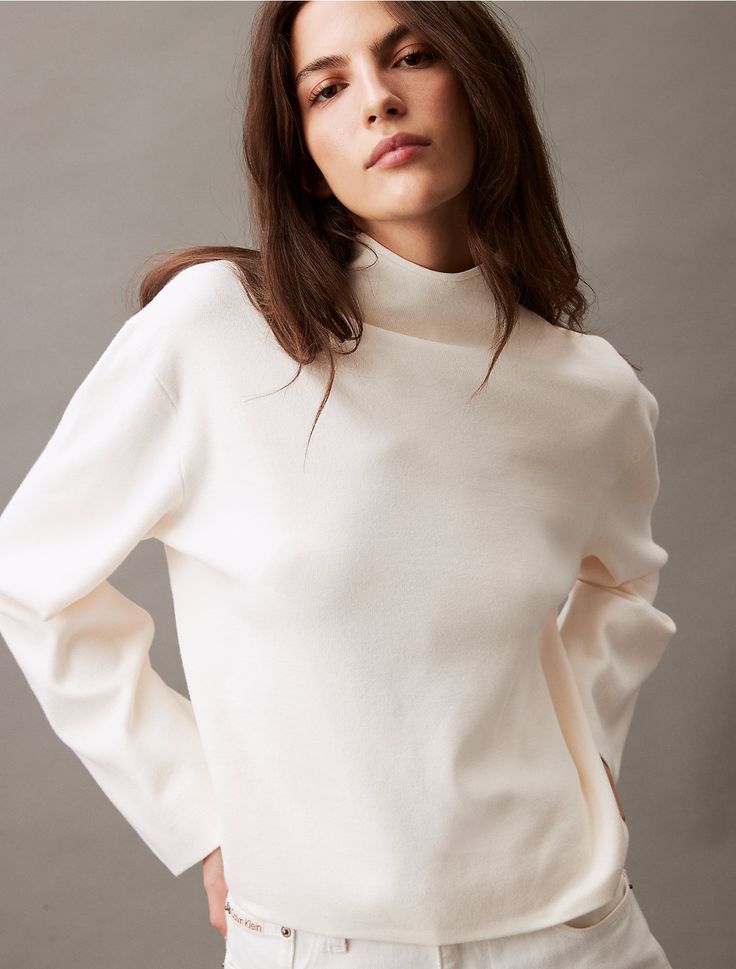 Woven with a half milano knit, this sweater is styled with long sleeves and a mock neck. Designed with drop shoulders for a relaxed fit. Created with simple, solid styling for a modern look.  Material: 72% Viscose, 28% Polyester.