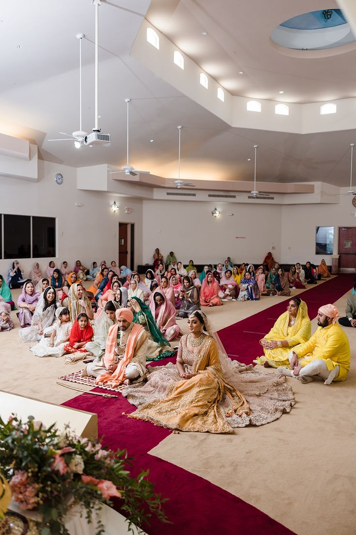 a group of people sitting on the floor in front of a room full of people