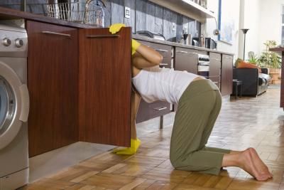 a woman is leaning over the kitchen sink and looking for something to put in her dishwasher