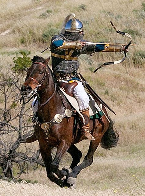 a man in armor riding on the back of a brown horse while holding a bow and arrow