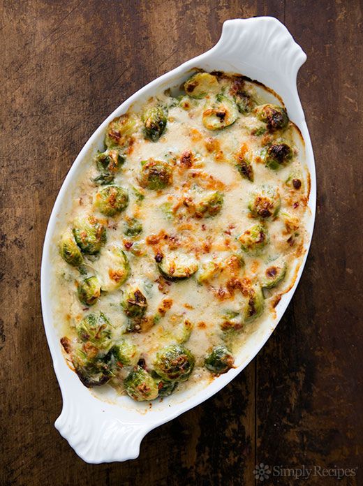 a casserole dish with broccoli and cheese in it on a wooden table