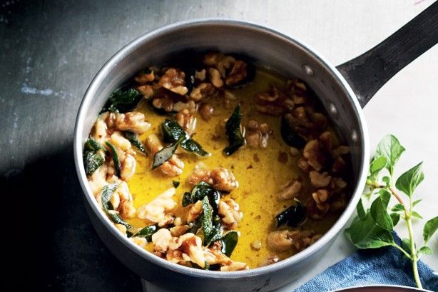 a pot filled with food sitting on top of a table next to a bowl of soup