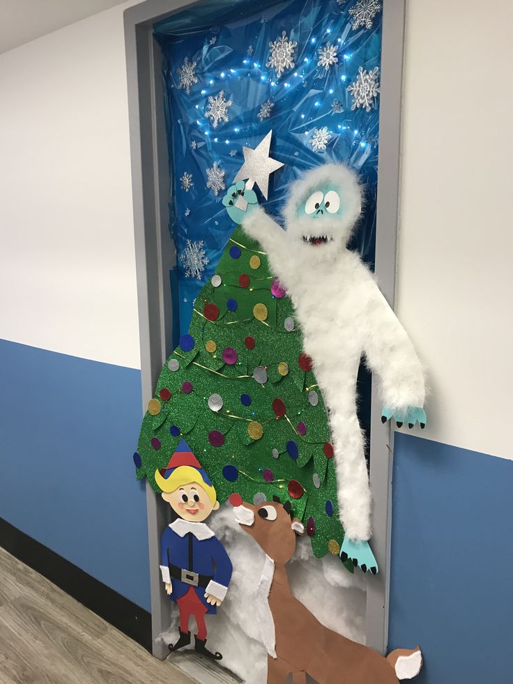 a door decorated to look like a christmas tree with an evil man standing next to it