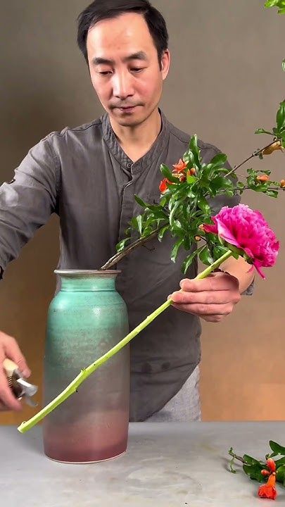 a man is arranging flowers in a vase