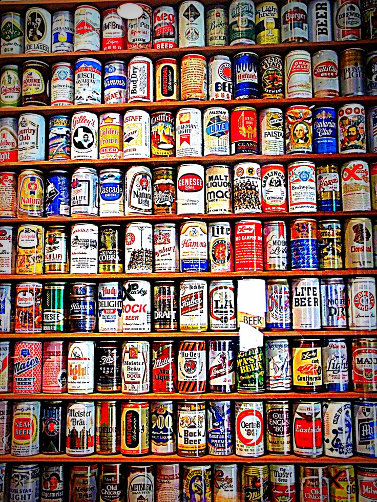 many different types of beer cans stacked on top of each other in a wall display