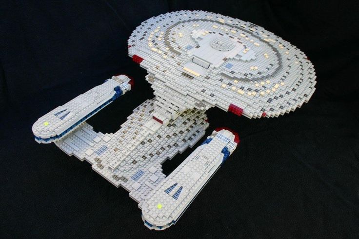 a lego model of a star trek ship on a black background with white and red trim