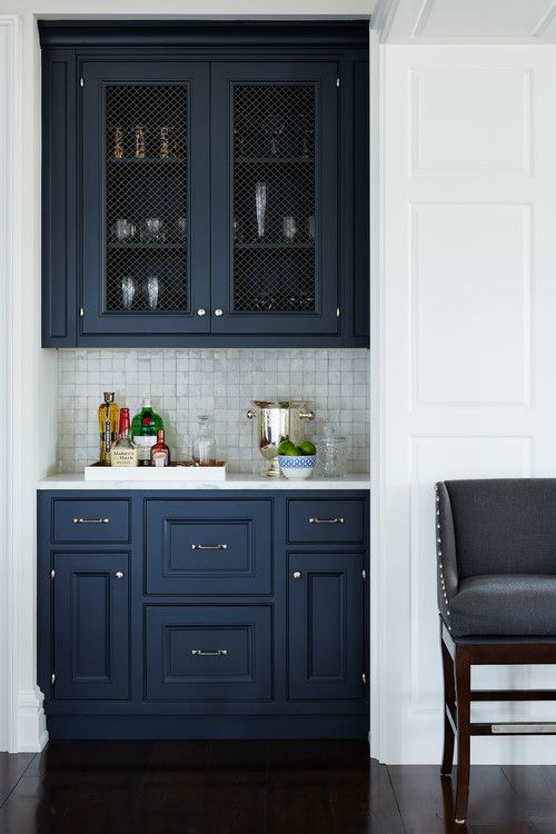 a kitchen with dark blue cabinets and white walls