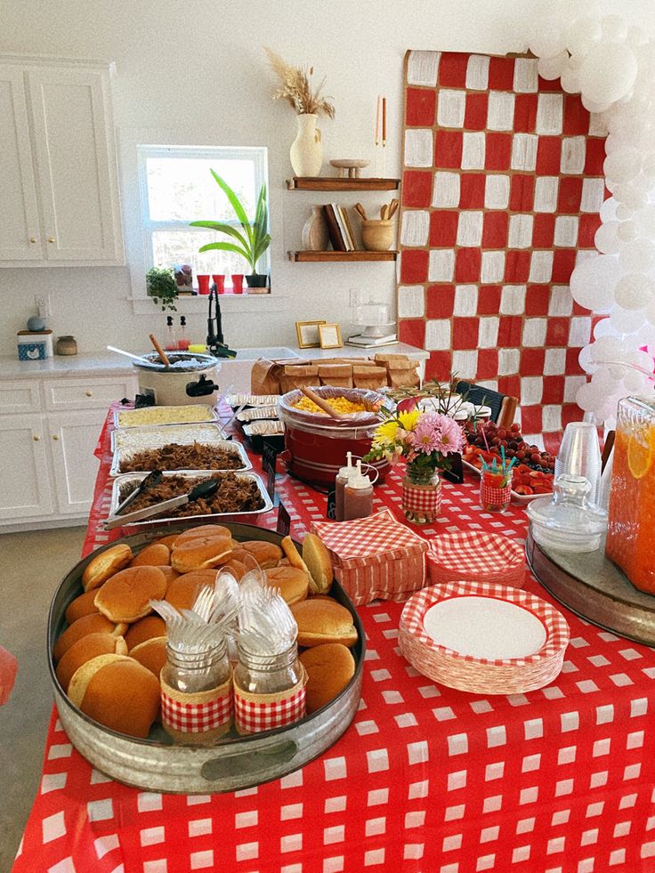 a red and white checkered table cloth with food on it, including muffins