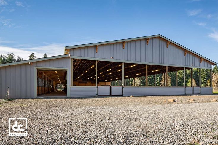 a large metal building sitting on top of a gravel field