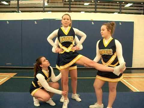 three girls in cheer uniforms standing on the floor