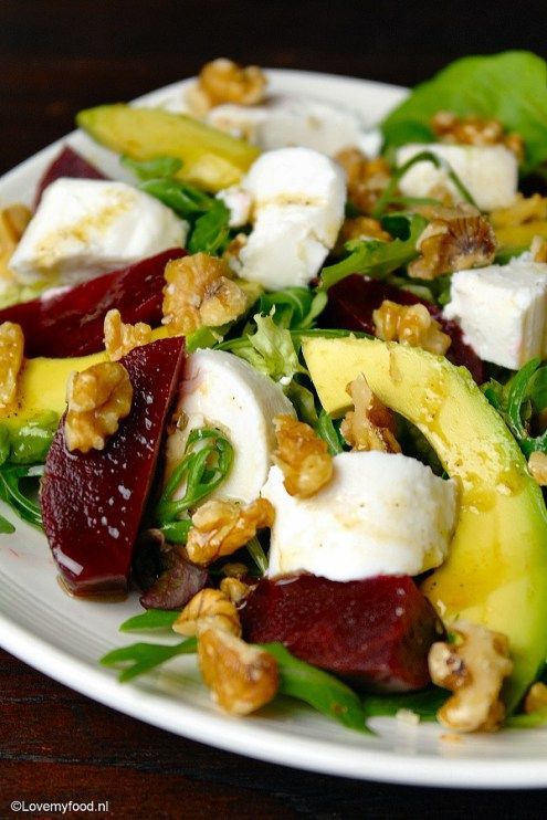 a white plate topped with beets, feta cheese and walnuts