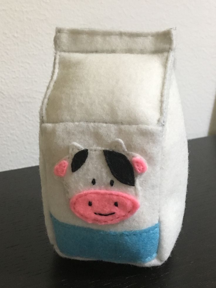 a small white bag with a cow on it's side sitting on a table