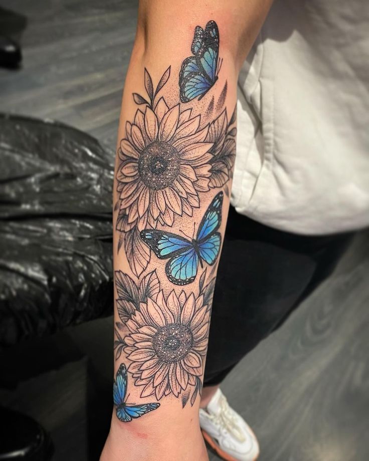 a woman's arm with sunflowers and butterflies on it