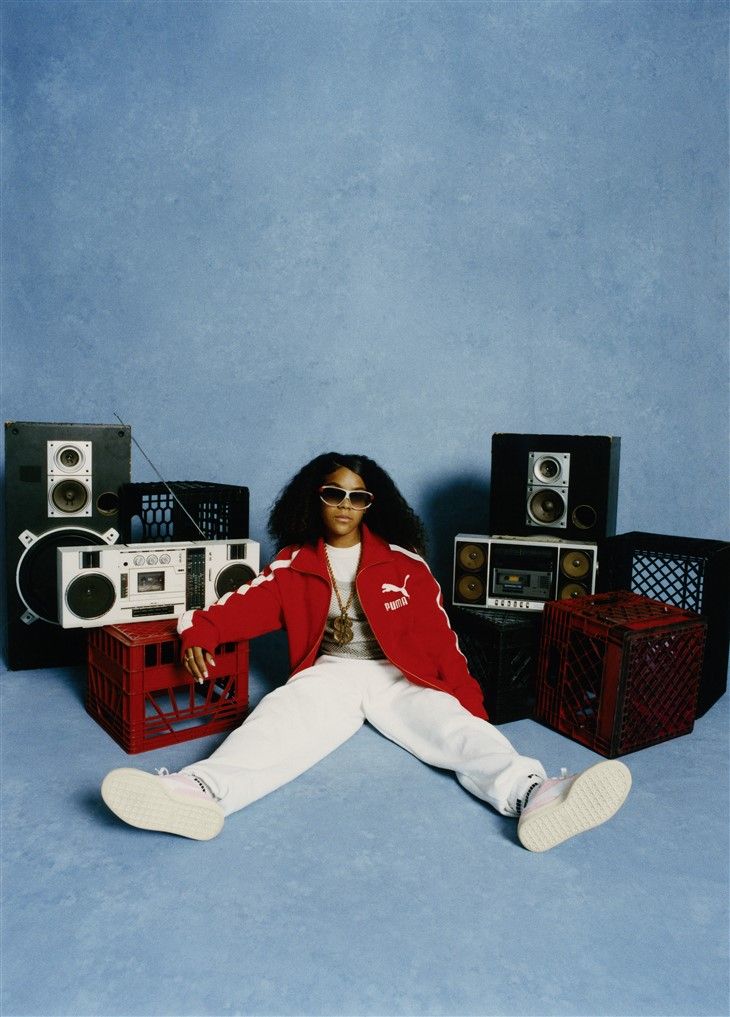 a woman sitting on the floor in front of speakers