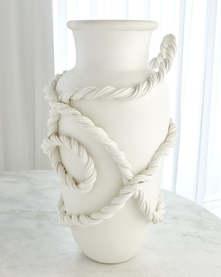 a white vase sitting on top of a table