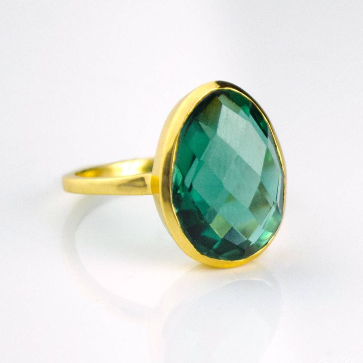 Get the "WOW" factor with this showstopper of a ring. The color of this tourmaline quartz stone is of a vibrant emerald green which is just stunning. Nicely sized with a soft teardrop or egg shape to it - one end is a bit more narrow than the other. Perfect in either 18k gold plated or 925 sterling silver. Gemstone size is 13mm x 16mm. Please note that due to the open back style of this ring, if you are between sizes, we recommend sizing down. Green Emerald Teardrop Rings, Teardrop Green Emerald Rings, Green Teardrop Emerald Rings, Teardrop Emerald Green Rings, Green Teardrop Emerald Ring For May Birthstone, Classic Green Teardrop Emerald Ring, Elegant Large Stone Green Emerald Ring, Green Tourmaline Teardrop Jewelry, Elegant Green Emerald Ring With Large Stone