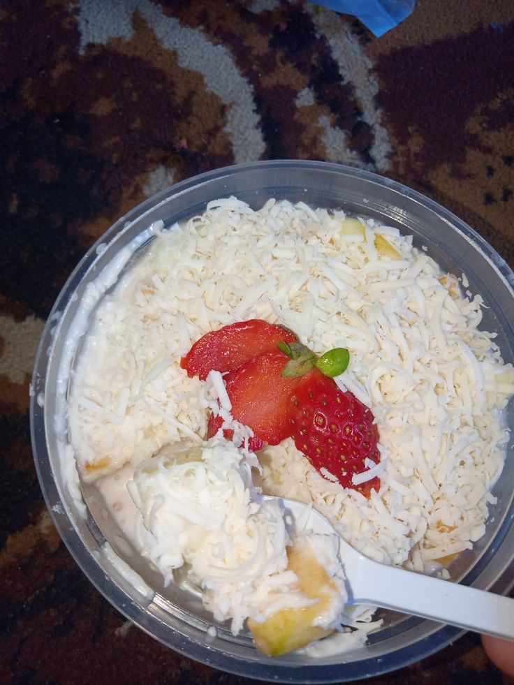 a plastic bowl filled with rice and strawberries