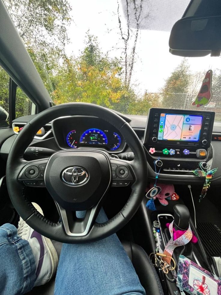 the interior of a car with someone's feet on the steering wheel