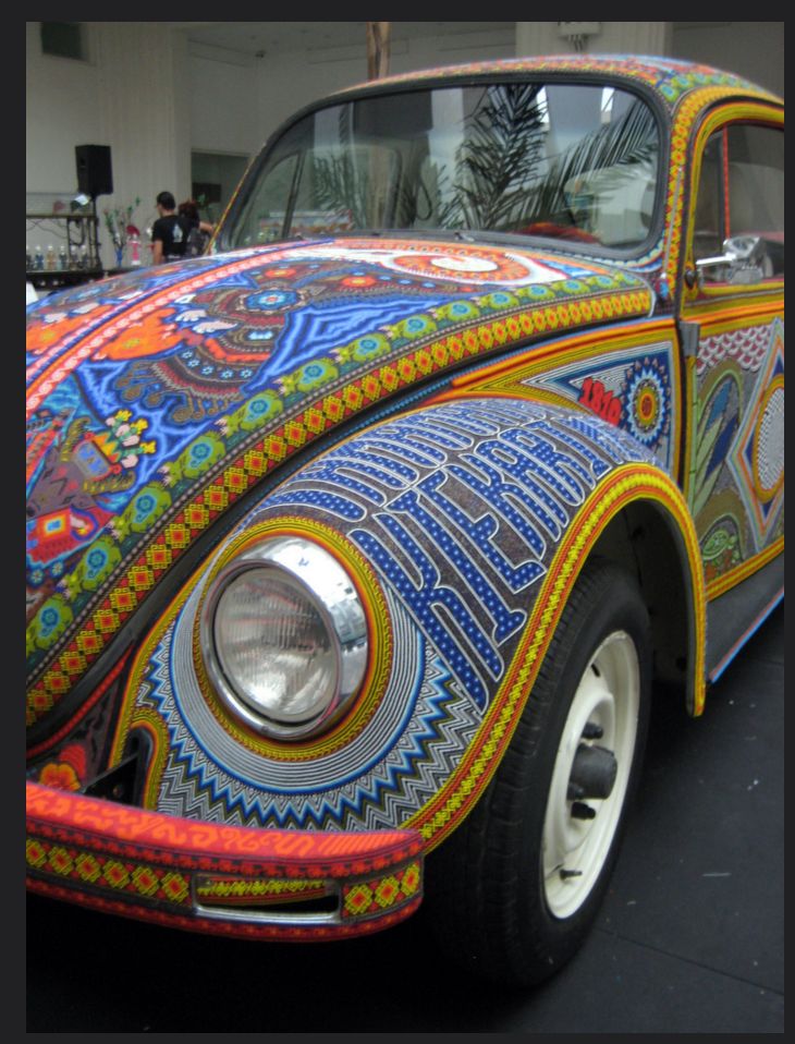 an old vw bug painted with colorful designs