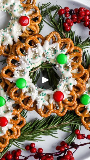 a white plate topped with pretzels covered in icing next to christmas decorations