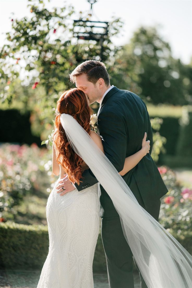 a bride and groom embracing each other in front of flowers