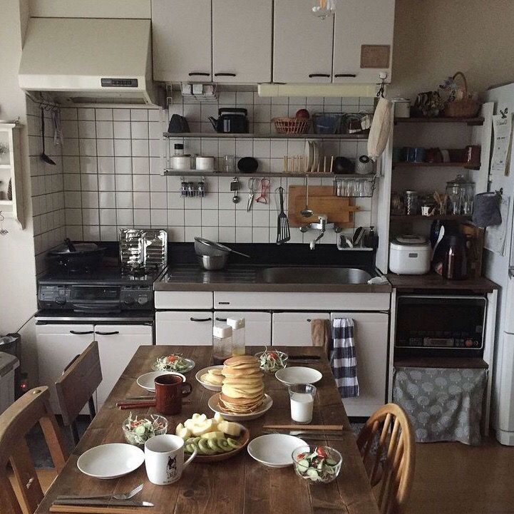 a table with plates and cups on it in a kitchen