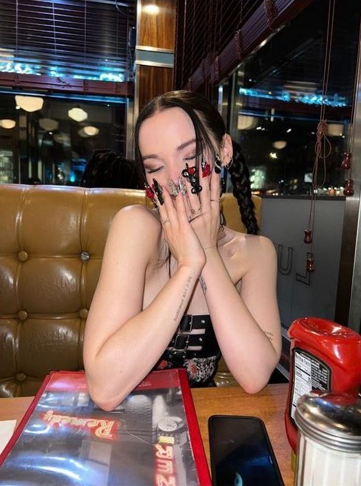 a woman sitting at a table with her hands covering her face