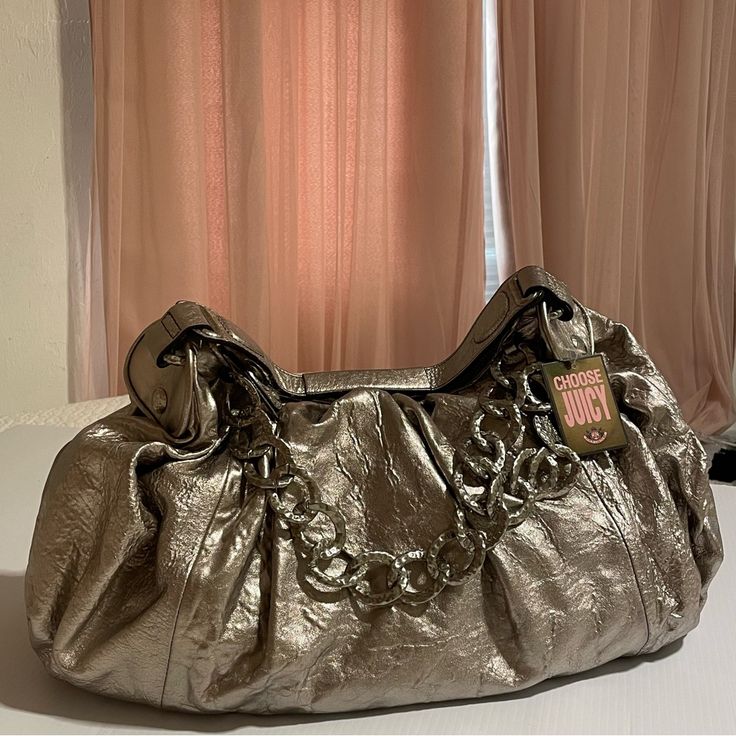 Juicy Couture Silver Bag. I Believe This To Be Very Rare And Vintage! It Has Been Sitting Away In Storage All Of Its Life. This Baby Comes With All The Original Packaging/Stuffing And New Tags! Only Flaw Is On The Zipper And Is Pictured. Sold As Is. Price Is Subject To Change, Please Send In Offers! Will Provide Measurements If Needed..Its Large. Elegant Metallic Satchel Bag, Metallic Tote Shoulder Bag, Elegant Style, Elegant Metallic Tote Shoulder Bag, Chic Gold Shoulder Bag With Silver-tone Hardware, Elegant Metallic Shoulder Bag For Travel, Elegant Metallic Shoulder Bag, Chic Metallic Bags With Silver-tone Hardware, Chic Metallic Bag With Detachable Handle, Chic Metallic Bags With Detachable Handle