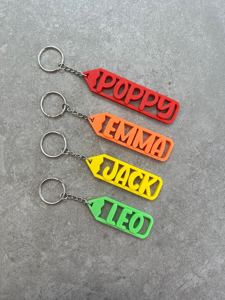 three keychains with the words poppy, tema, jack and leo on them