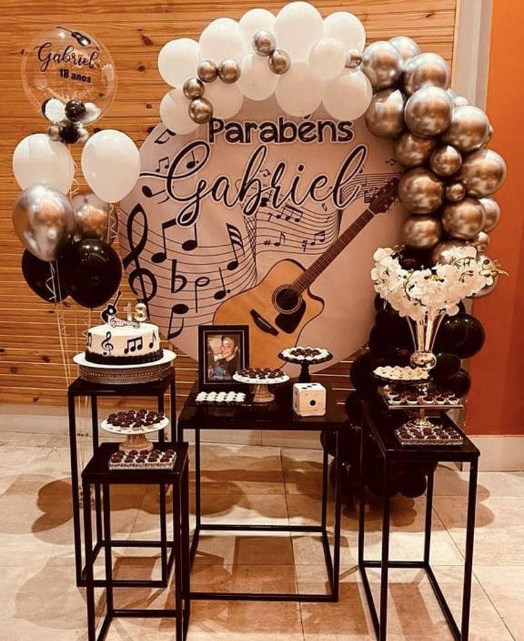 some black and white balloons are on display in front of a wall with music notes