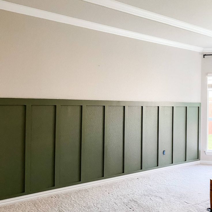 an empty room with green paneling on the walls