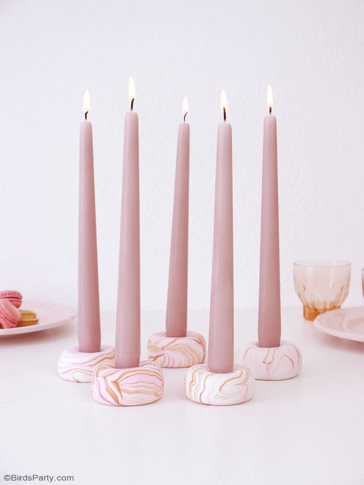 pink candles are lined up on a white table