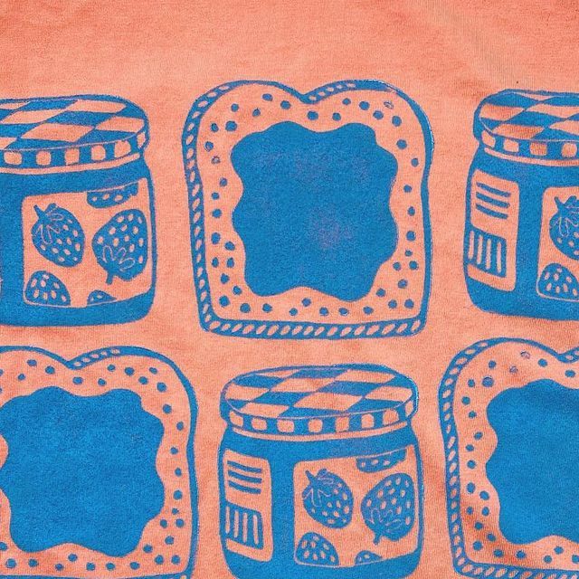 a t - shirt with blue images of jams and bread in jars on an orange background