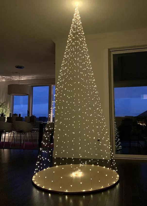 a lighted christmas tree in the middle of a room