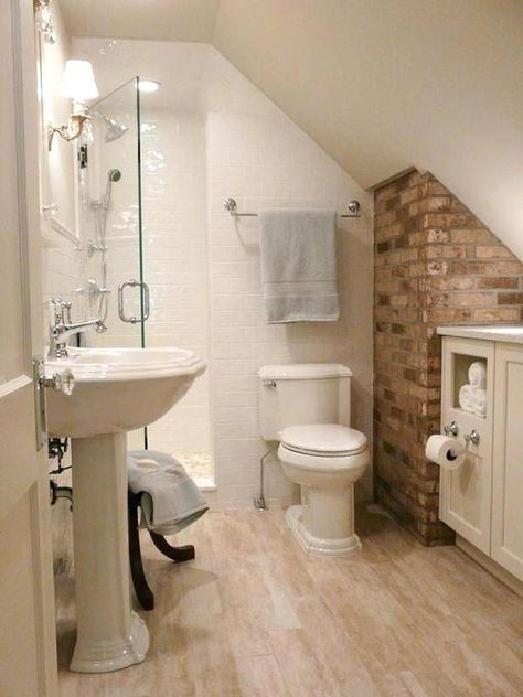 an attic bathroom with white fixtures and wood floors