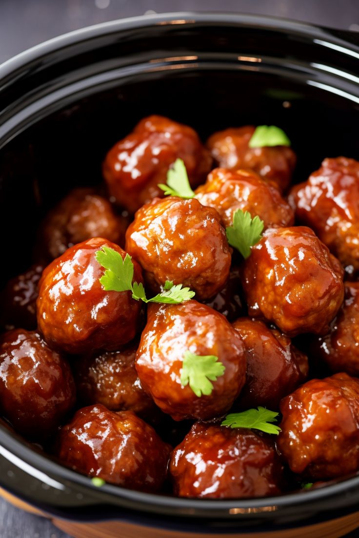 the meatballs are covered in sauce and garnished with cilantro leaves