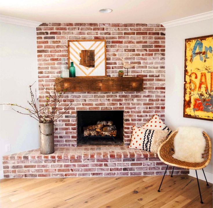 a living room with a brick fireplace and pictures on the wall