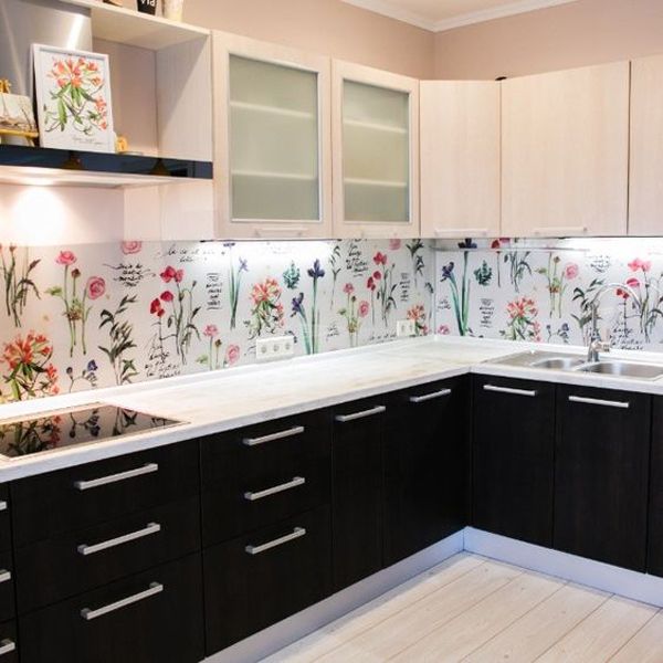 a kitchen with black cabinets and white countertops has flowers painted on the backsplash