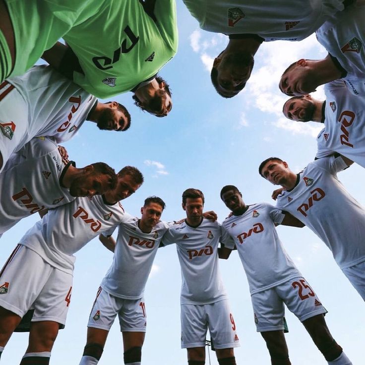 a group of soccer players standing in a circle