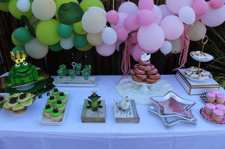 a table topped with lots of desserts and balloons