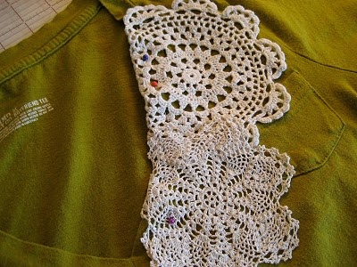 a white crocheted tie laying on top of a green shirt