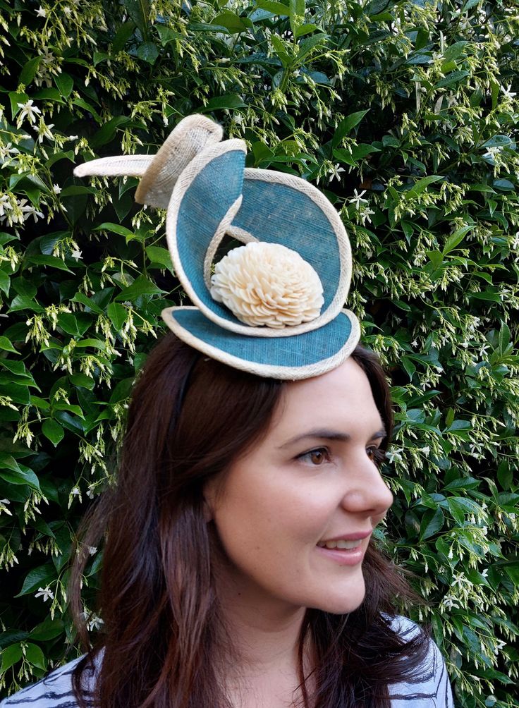 Teal cocktail hat with cream trimming. Made from sinamay, it is attached to an Alice band for easing wearing. The perfect statement hat for Spring Racing 2023! Also ideal for a wedding, high tea-party, baby shower, bridal shower, cocktail party or special occasion. Summer Garden Party Headpiece With Pinched Crown, Summer Garden Party Headpiece With Structured Crown, Structured Crown Fascinator For Garden Party, Sinamay Fascinator With Curved Brim For Royal Ascot, Cream Straw Hat For Spring Party, Sinamay Straw Hat With Curved Brim For Party, Brimmed Sinamay Mini Hat For Royal Ascot, Summer Party Mini Hat With Round Crown, Summer Fascinator With Round Crown