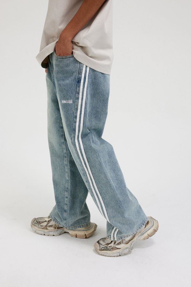 The Washed Striped Wide-Leg Pants seamlessly blend vintage style with contemporary craftsmanship. Featuring an all-over washed and distressed look, these pants are adorned with embroidered logos on each hip. The striking contrast stripes run from the back waist down the front of the legs, enhancing the body’s natural silhouette. Functional front pockets are decorated with rivets, while two back pockets provide additional utility. Crafted from premium fabric, these slightly oversized pants offer Casual Cotton Bottoms With Contrast Stitching, Sporty Straight Leg Bottoms With Contrast Stitching, Vintage Streetwear Bottoms For Spring, Sporty Relaxed Fit Wide Leg Jeans, Sporty Wide Leg Denim Pants, Sporty Wide Leg Relaxed Fit Jeans, Sporty Wide Leg Jeans With Relaxed Fit, Cotton Jeans With Contrast Stitching For Streetwear, Casual Straight Leg Pants With Contrast Stitching