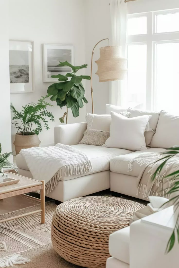 a living room with white furniture and plants