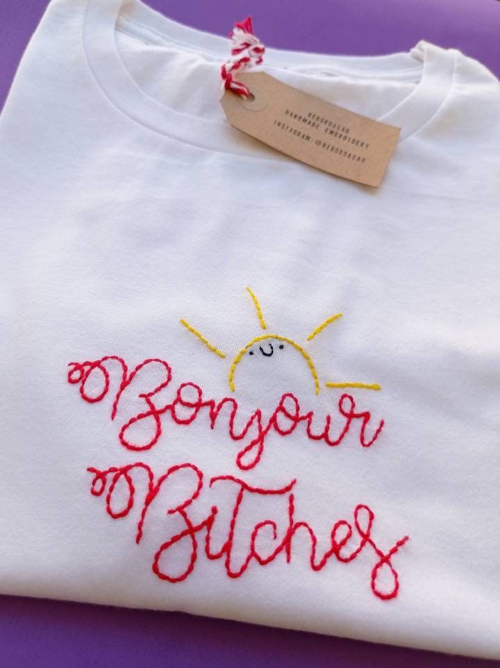 a white shirt with embroidered words on it