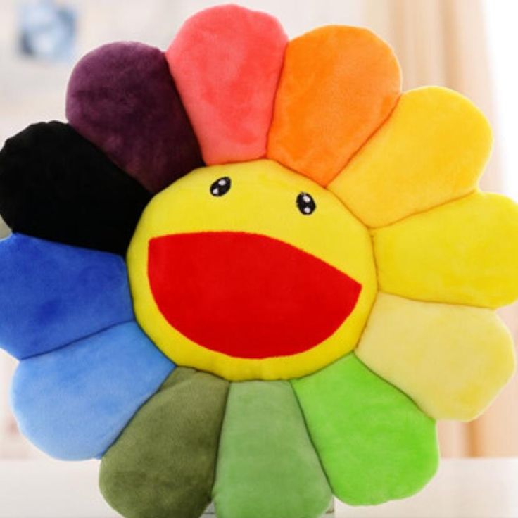 a multicolored flower shaped plush toy sitting on top of a table