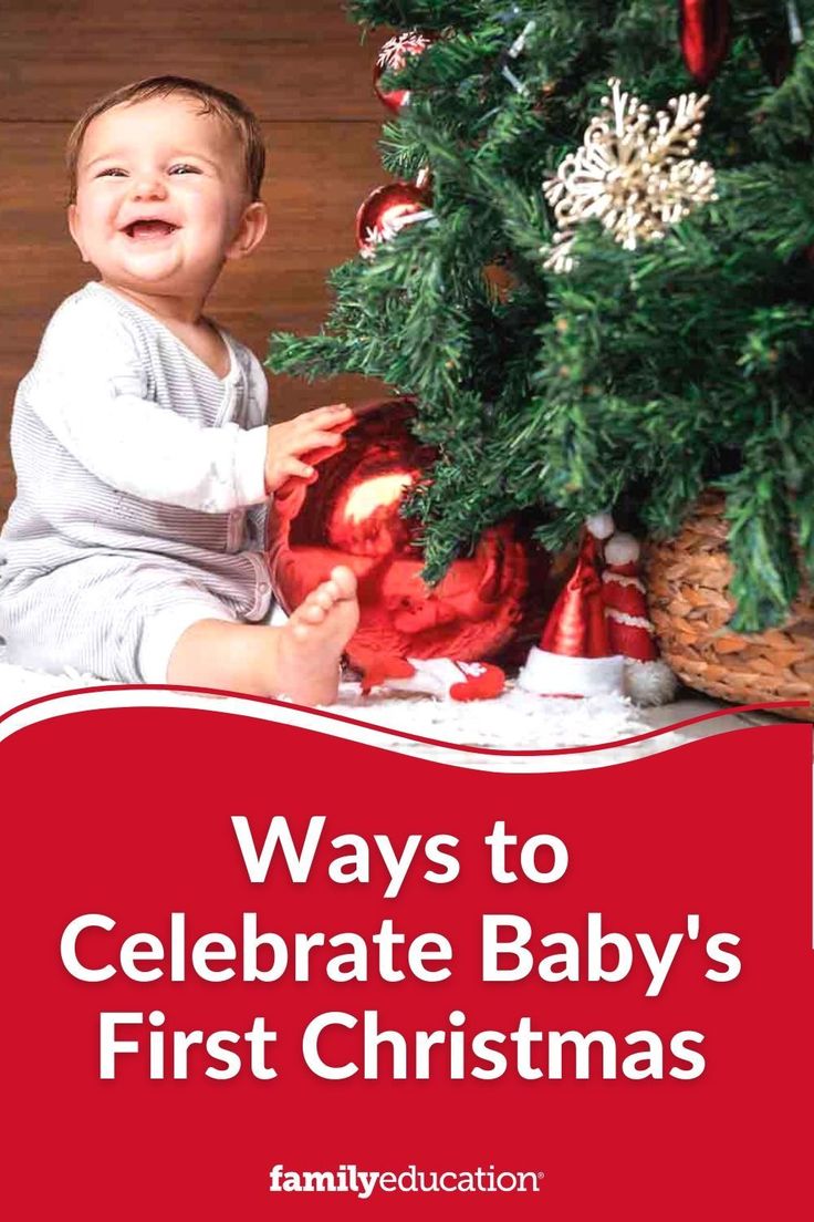 a baby sitting next to a christmas tree with the words, ways to celebrate baby's first christmas